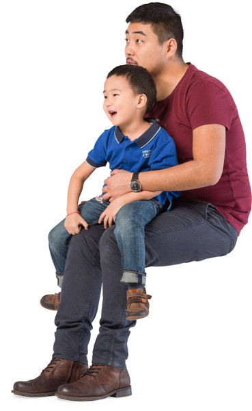 Son sits on father's lap image