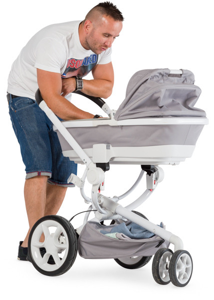 Young father calms the child in the pram image